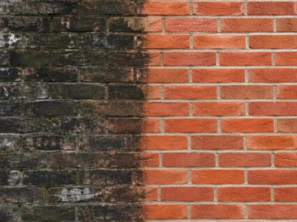 Brick Cleaning in Yorkshire Brick wall showing a dirty blackened half beside a freshly cleaned warm red half
